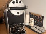 a coffee maker sitting on a shelf next to a cup of coffee