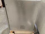 a metal dishwasher sitting on a pallet in a warehouse
