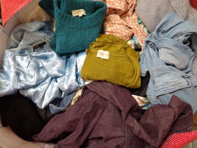 a basket full of clothes that is sitting on the floor