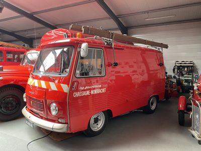 un camion de pompiers rouge garé dans un garage à côté d'autres camions rouges