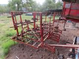 an image of a red farm equipment in a field
