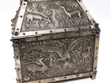 an old silver box with a design of animals on it