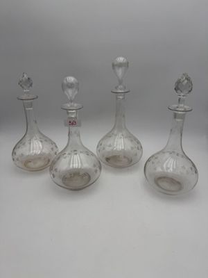 quatre carafes en verre surmontées d'un oiseau