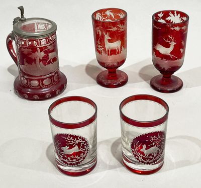 four red glass cups and a mug with a deer design on them