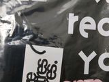 a black bag with stickers on it that says recycle you