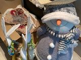 un bonhomme de neige portant un bonnet et une écharpe, à côté d'une valise