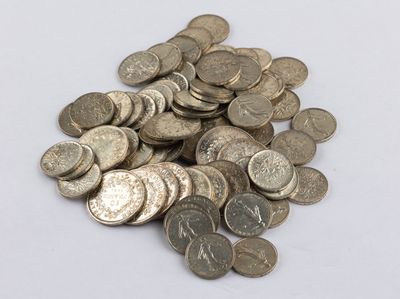 a pile of silver coins on a white surface