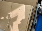 une pile de cartons posée par terre près d'une fenêtre