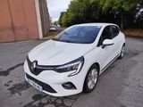 une voiture blanche garée dans un parking à côté d'un bâtiment