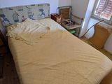 a bed in a room with a yellow comforter