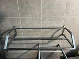 a metal rack that is in the corner of a bathroom