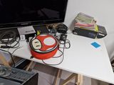 a nintendo wii controller sitting on a desk next to a monitor