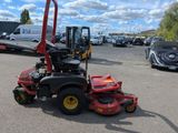 a picture of a red ride on mower parked in a parking lot
