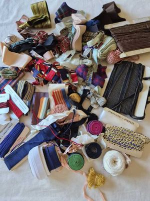 a pile of ties and other items on a bed