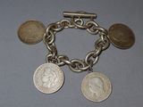 un bracelet en argent orné de pièces, posé sur une table