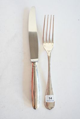 deux fourchettes et un couteau sur une table blanche