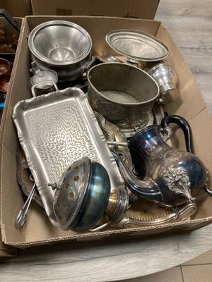 une boîte remplie d'objets en argent posée sur une table
