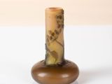 a small vase with a brown base on a white surface