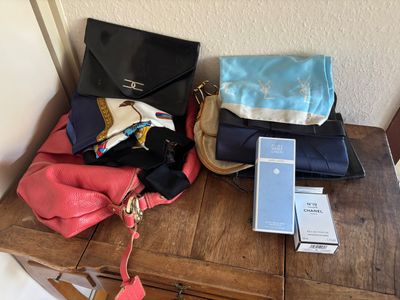 plusieurs sacs à main et un téléphone portable posés sur une table en bois