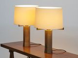 two lamps on a wooden table with a white lamp on top of it