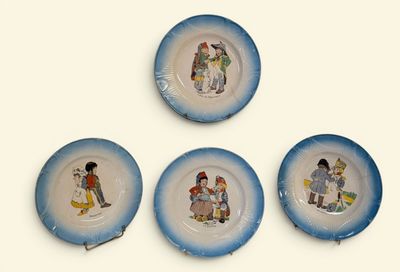 quatre assiettes bleues et blanches ornées de personnages de dessins animés, posées sur un fond blanc