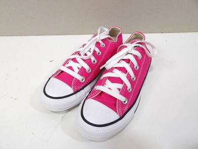 pink converses with white laces are on a white surface