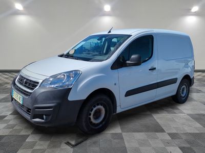 une camionnette blanche garée dans une pièce au sol en damier