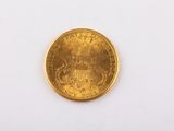 gros plan d'une pièce d'or sur une surface blanche