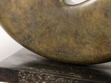 a bronze sculpture of a doughnut on top of a base