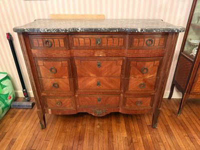 une commode au plateau en marbre dans une pièce avec du parquet