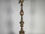 un bougeoir ancien en laiton surmonté d'une bougie