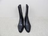 a pair of black leather ankle boots on a white surface