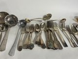 a lot of silverware on the table with spoons and spoons