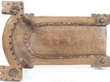 a wooden plaque with rivets on it on a white surface