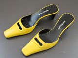 une paire de chaussures jaunes posées sur une surface grise