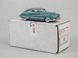 une petite voiture verte posée sur une boîte