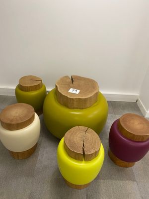 four different colored stools with wooden tops on the floor