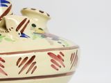 a vase with a bird on it sitting on a table