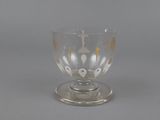 a glass cup with a cross on it on a table