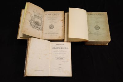 trois livres ouverts posés les uns sur les autres sur une surface noire