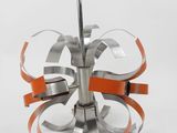 a silver and orange metal sculpture with a clock on top of it