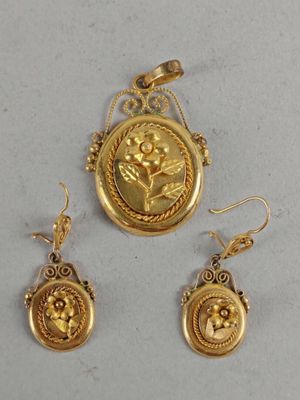 a close up of a gold necklace and earrings with a picture of a woman