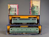 two green trains in a blue box on a table