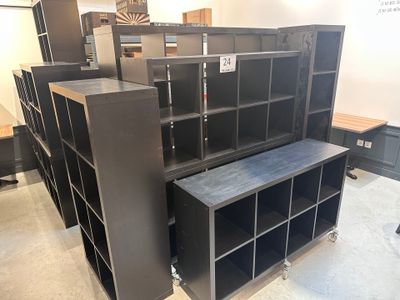 de nombreuses armoires noires dans une pièce où se trouve une table