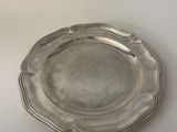 silver plate with scalloped edge on a white surface