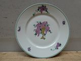 une assiette blanche ornée de fleurs violettes, posée sur une table