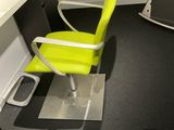 a yellow chair sitting in front of a computer desk