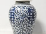 un vase bleu et blanc avec un couvercle posé sur une table