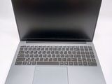 a silver laptop with a black keyboard on a white surface