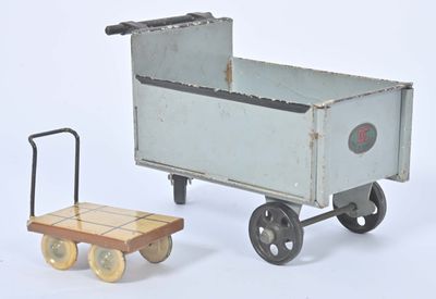 un petit chariot jouet surmonté d'une remorque en bois